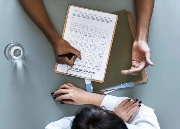 Aerial view of doctor writing patient daily report checklist aerial view doctor writing patient daily report checklist 1 E&M: Desarrollo Corporativo