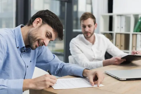 side view smiley man signing work contract E&M: Desarrollo Corporativo