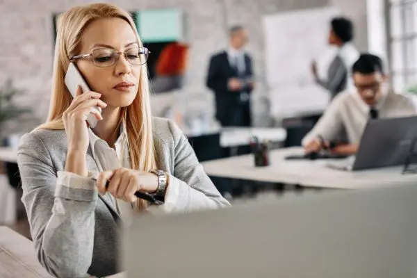 Serious businesswoman making a phone call while working in the o referencias-laborales-panama